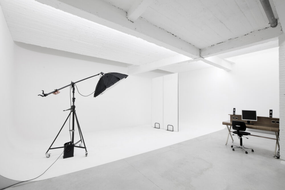 Studio photo B situé à Anvers avec des murs blanc et matériel photographique